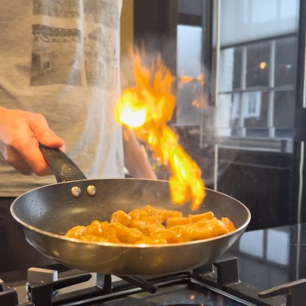 Gnocchi in a frying pan, and flames coming from the pan